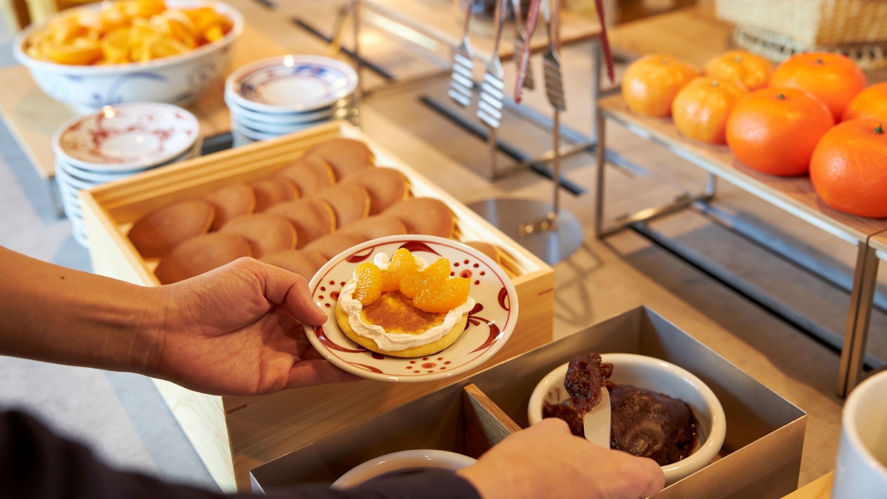 A buffet with various food items including pastries, fruits, and a bowl of ice cream.