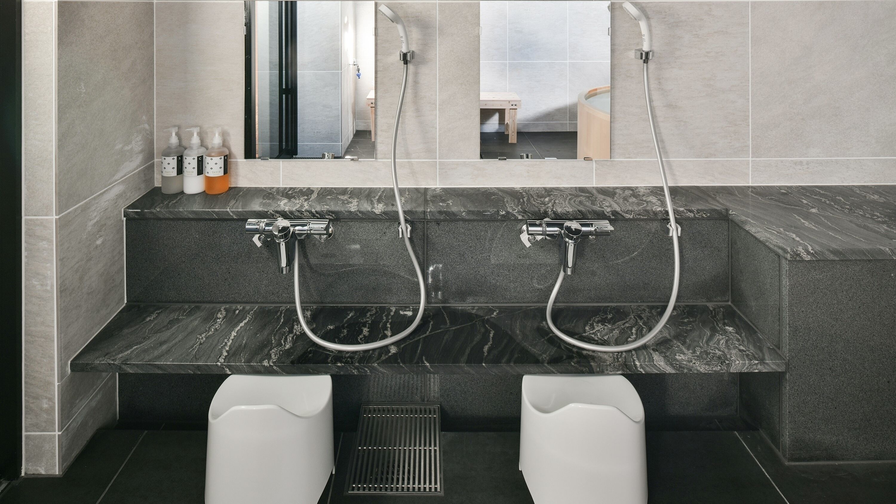 Un baño moderno con dos lavamanos, un espejo y zona de ducha.