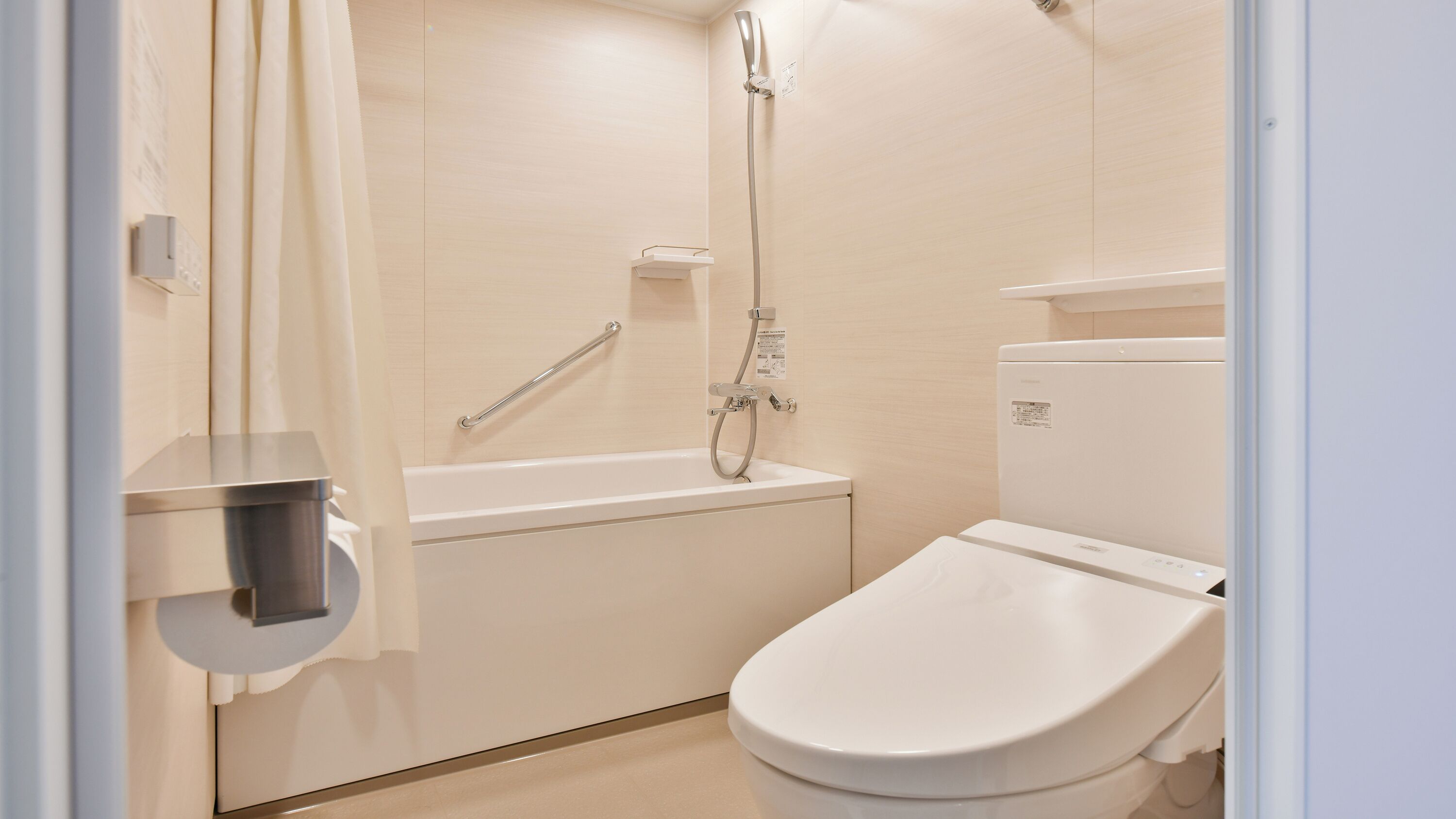 A modern bathroom with a shower, toilet, and a small shelf.