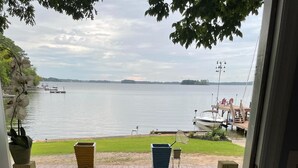 A wooden deck with a doormat reading "Lakeside" and a view of a lake with boats and a dock. - Million Dollar Sunrise View (Batesburg-Leesville)