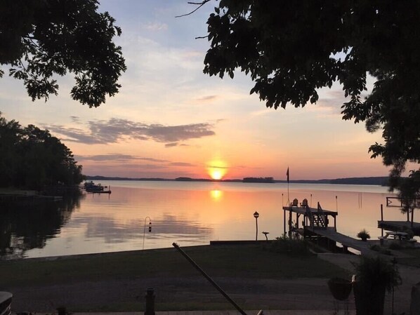 A sunset view over a calm lake with a dock and chairs, surrounded by trees. - Million Dollar Sunrise View (Batesburg-Leesville)