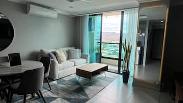 Una sala moderna con sofá, mesa de centro y comedor.