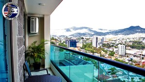 Un balcón con vistas a un paisaje urbano y montañas.