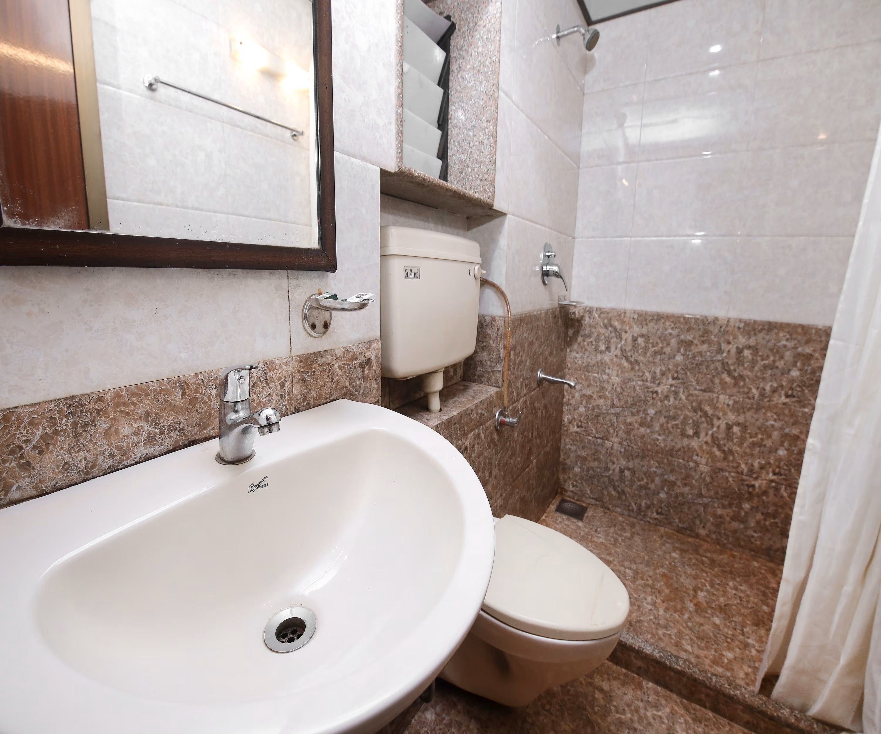 A bathroom with a white sink, a toilet, and a shower area.