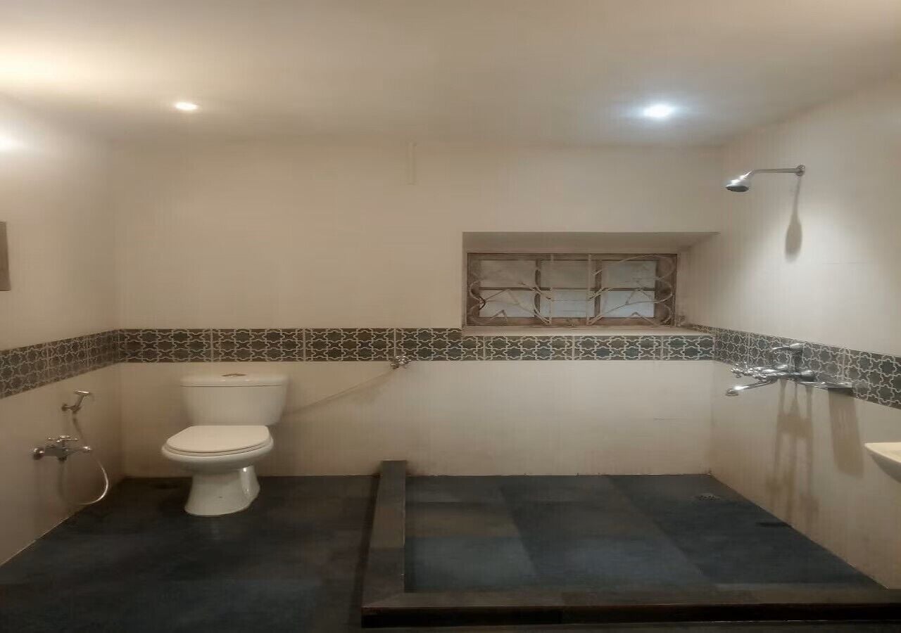 A bathroom with a toilet, a shower, and a sink.