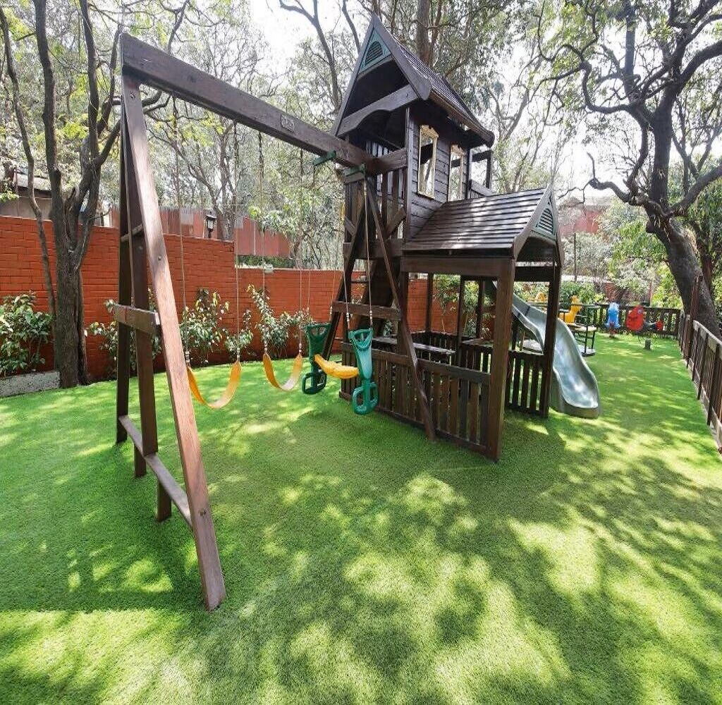 A playground with a swing set, slide, and climbing structure.