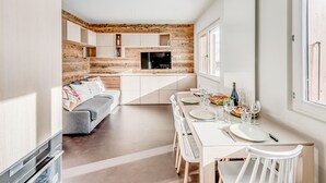 A modern kitchen with a built-in oven and a dining area with a table set for two. - Renovated apartment for 4, lake view, hotel services (Tignes)