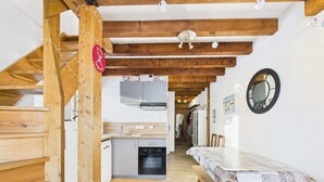 Ein Holzinnenraum mit Küche, Essbereich und Treppe.