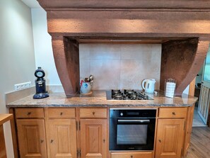 Eine Küche mit eingebautem Herd, Backofen und Kaffeemaschine.