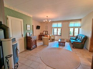 A spacious living room with a fireplace, a dining area, and a sofa.