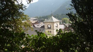 A town with a prominent clock tower, surrounded by mountains and dense foliage. - Studio for 2 close to Samoëns center (Samoëns)