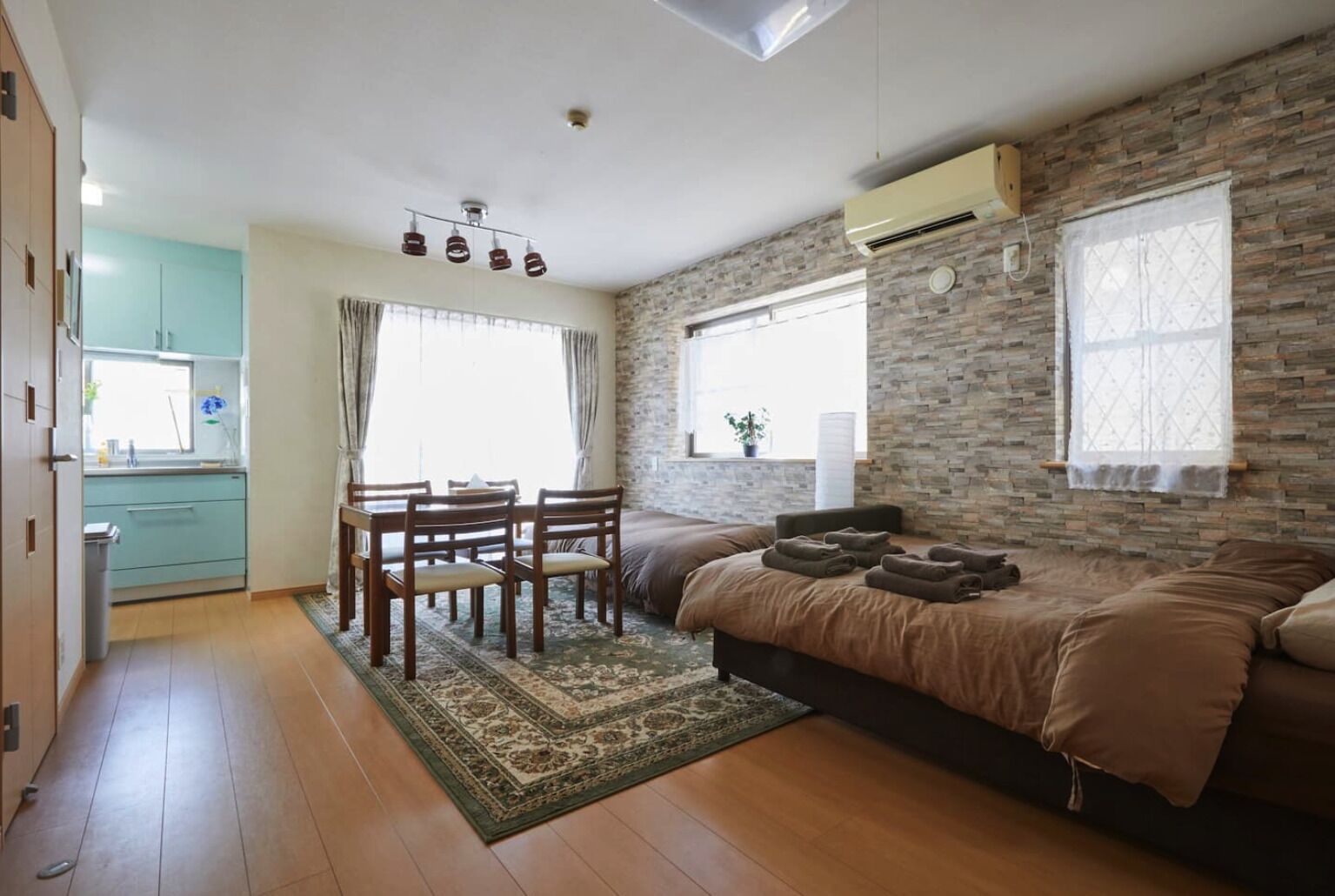 A compact living space with a kitchenette, a dining area, and a bed.