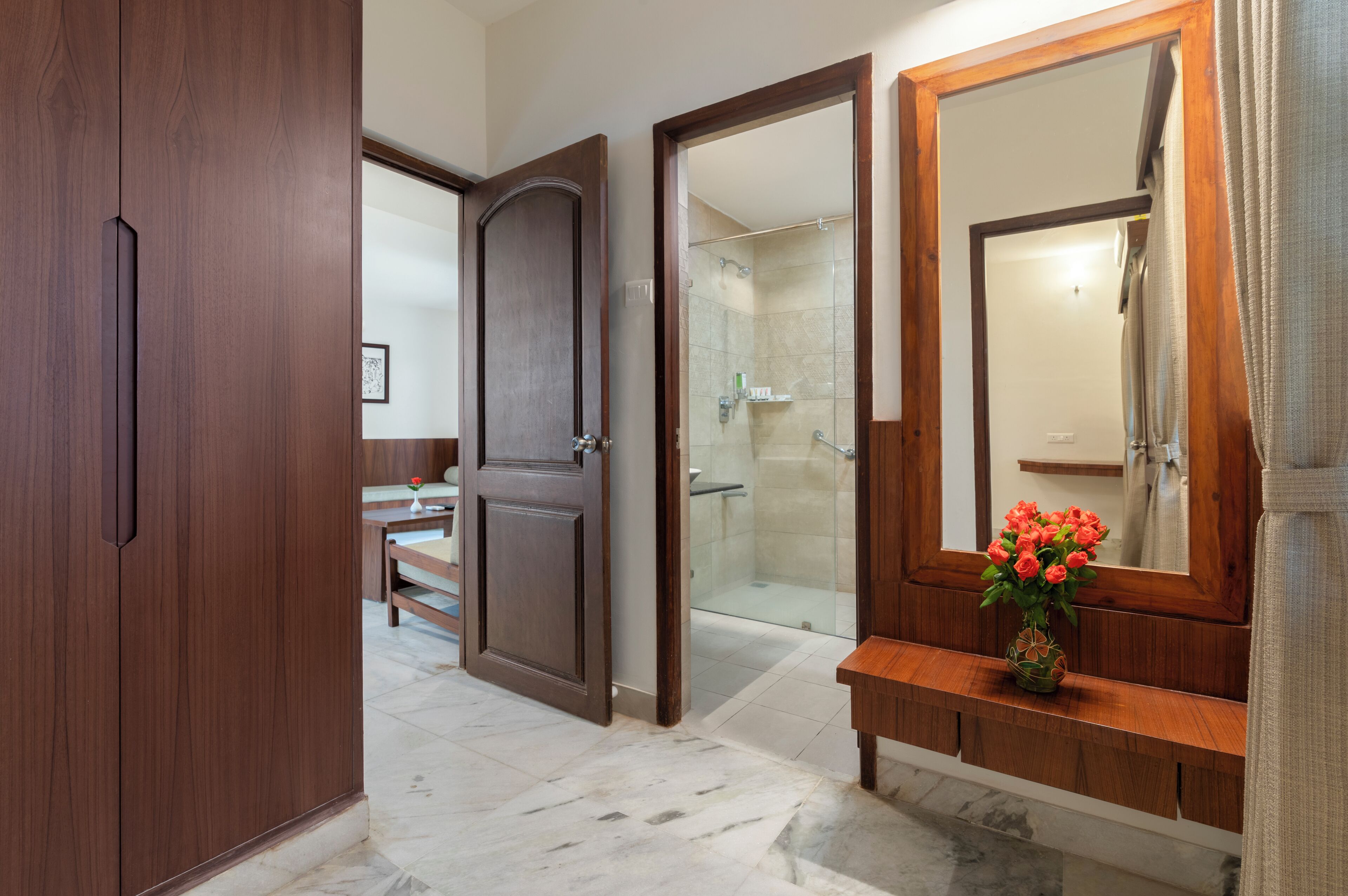 A bathroom with a wooden vanity, a large mirror, and a shower area.
