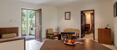 Un comedor moderno con una mesa de madera, dos sofás color beige y un mueble de madera.