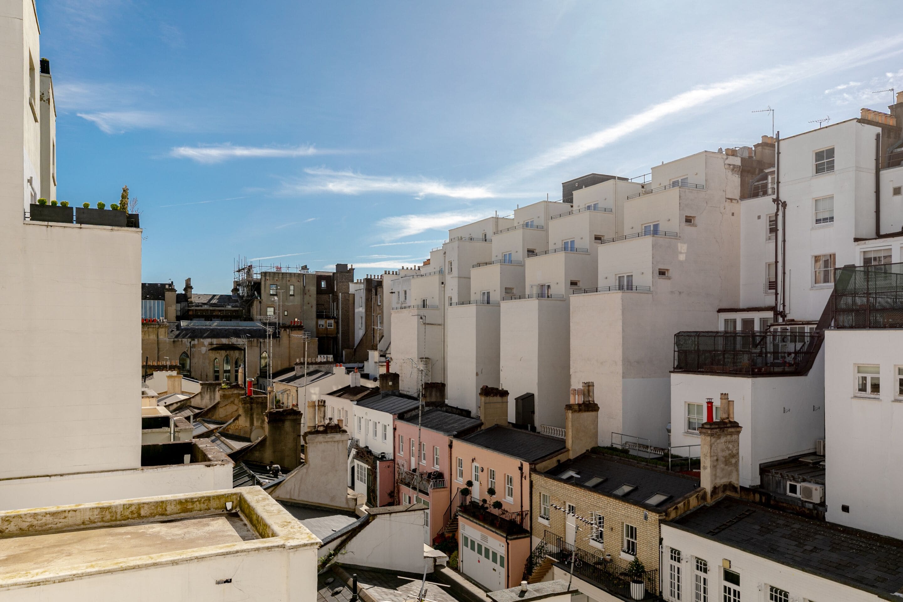 Uma área urbana densamente povoada com edifícios de vários andares, alguns com sacadas e outros com terraços.