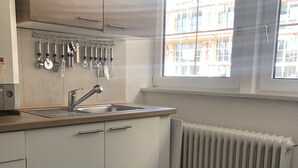 A small kitchen with a sink, a window, and a radiator. - Apartment COLIN (Bremerhaven)