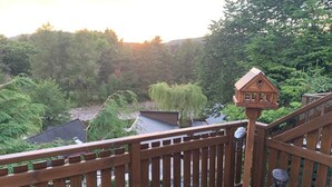 Eine Holzterrasse mit einer Statue eines Mannes und einem Vogelhäuschen.