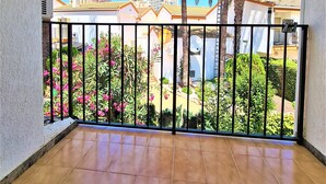 A balcony with a view of a garden, palm trees, and high-rise buildings. - Ola Azul bungalow V (Benidorm)