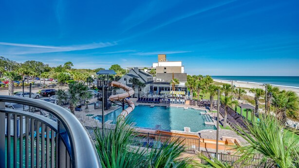 Ein Resort mit Pool, Wasserrutsche und Blick auf den Strand.