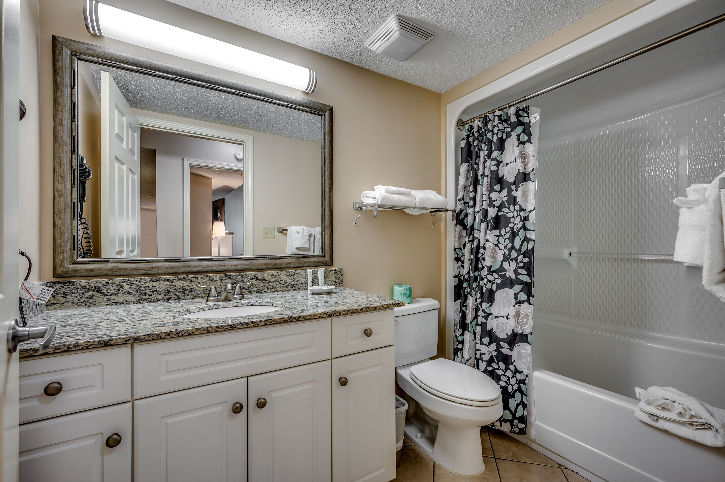 A bathroom with a sink, toilet, and shower.