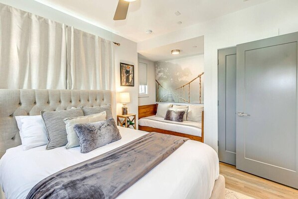 Un dormitorio moderno con una cama grande, un sofá y una puerta.