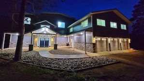 A modern two-story house with a stone facade, a covered entryway, and a garage with two doors.
