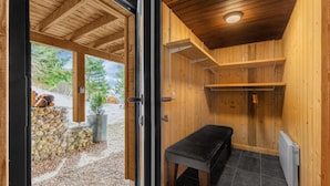 A wooden sauna with a bench, a radiator, and a view of a snowy outdoor area. - Grand Chalet Standing Avec Jacuzzi à Chamrousse ski 1750 (Chamrousse)