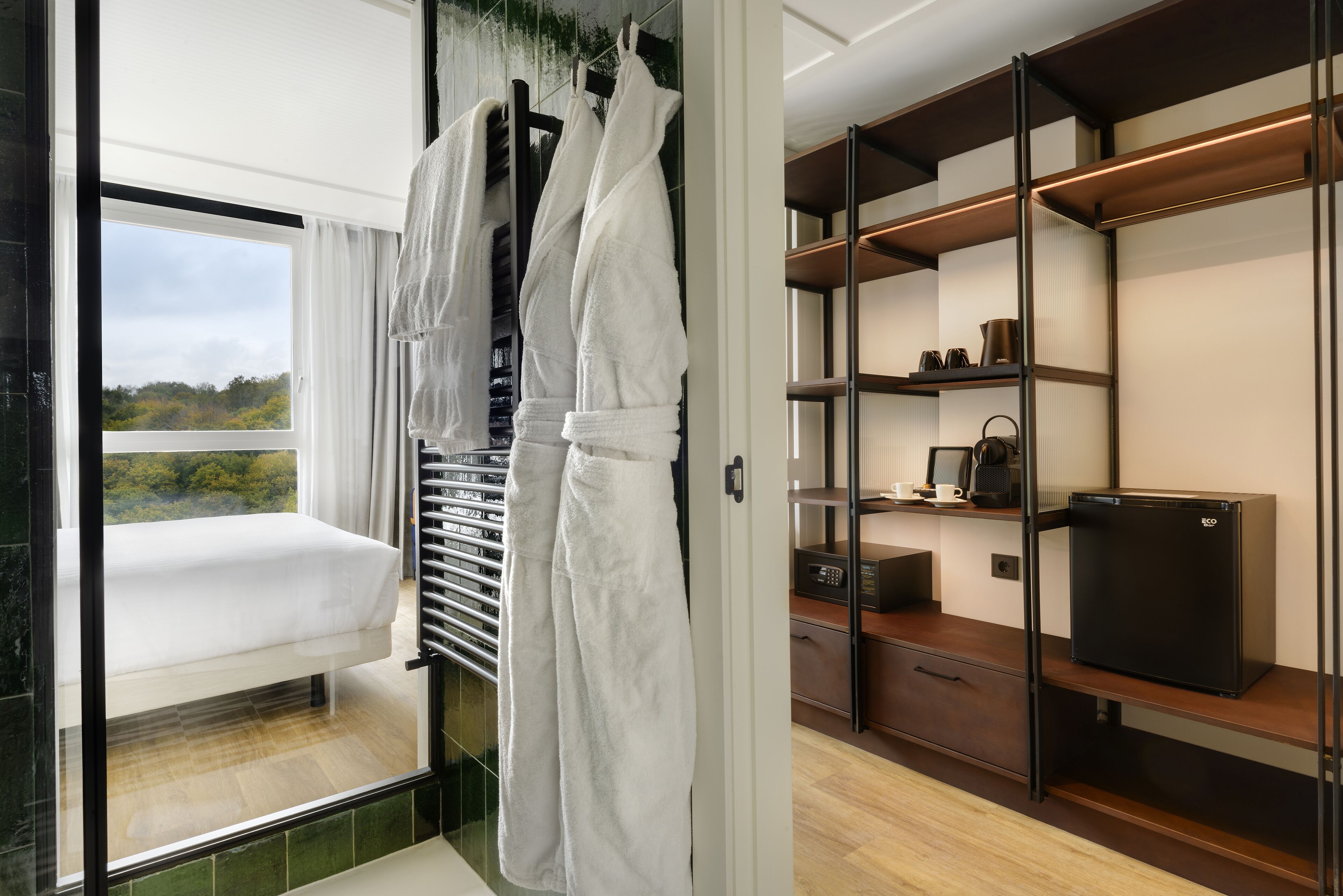 A hotel room with a balcony, a minibar, and a compact refrigerator.