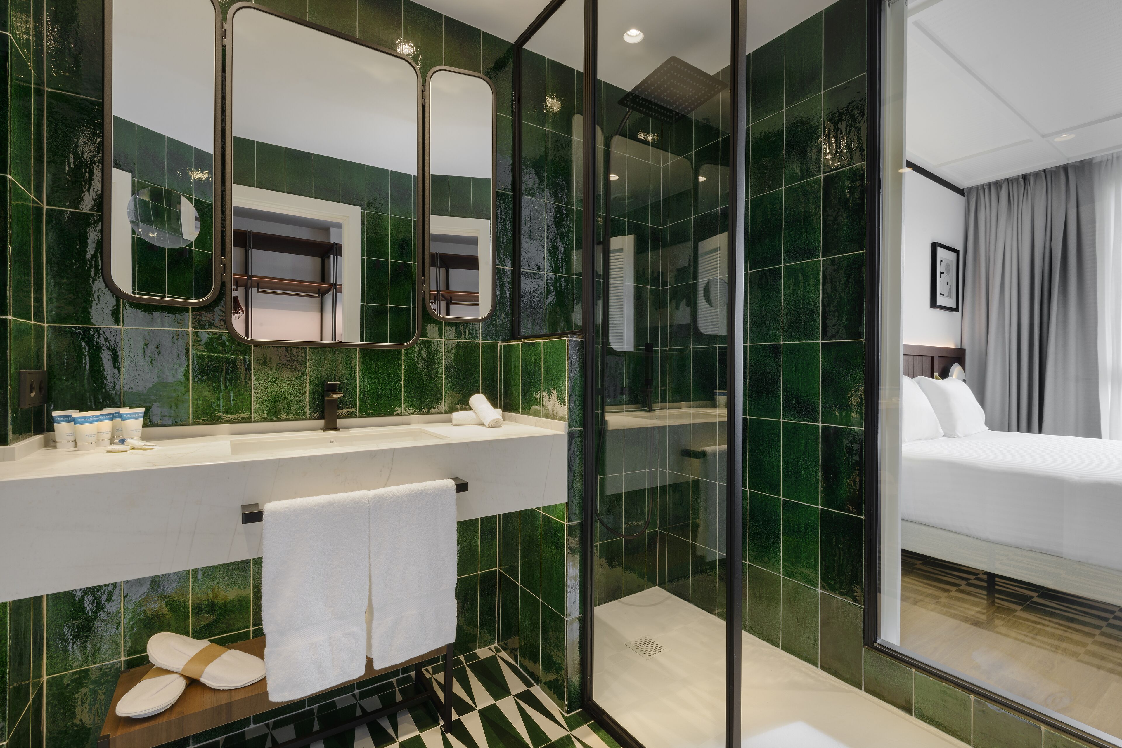 Un baño moderno con cabina de ducha de vidrio, un espejo grande y un lavabo blanco.