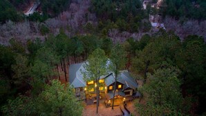A lodge with multiple cabins surrounded by dense forest, accessible by a dirt road. - "Rustic Mountain Lodge" Bunk Room, Outdoor Entertaining, Pets (Broken Bow)