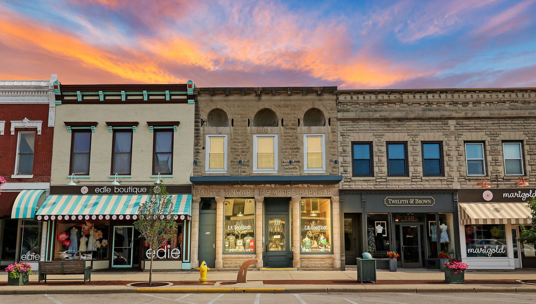 Una hilera de edificios históricos con locales comerciales, incluyendo 'Edie Boutique' y 'Twelfth & Brown'.