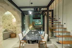 Enjoy meals in the central dining area with a marble table and comfortable white chairs.