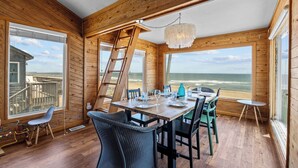 A wooden cabin with a dining area overlooking the ocean. - Oceanfront Dog Friendly Home w/ Hot Tub & Grill (Avon)