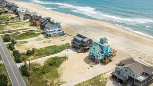 A coastal residential area with beachfront properties featuring multi-level structures and direct ocean views. - Oceanfront Dog Friendly Home w/ Hot Tub & Grill (Avon)