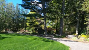 A well-maintained park with a paved path, green grass, and various trees. - Cozy Dog Friendly House with Deck, Firepit & Fast WiFi in Heart of Bar Harbor (Bar Harbor)