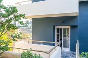A modern building with a balcony, a door, and a view of the surrounding area. - CHROMA Lodge Rafina (Rafina-Pikermi)