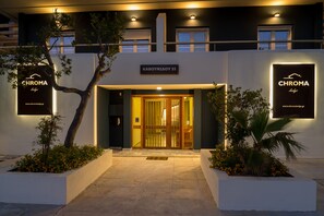The exterior of a hotel named 'CHROMA' with a modern facade, a sign above the entrance, and well-maintained landscaping. - CHROMA Lodge Rafina (Rafina-Pikermi)