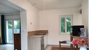 A modern kitchen with a wooden countertop, a sink, and a window overlooking greenery. - A L'arborée de Clénord (Clénord-Cellettes)