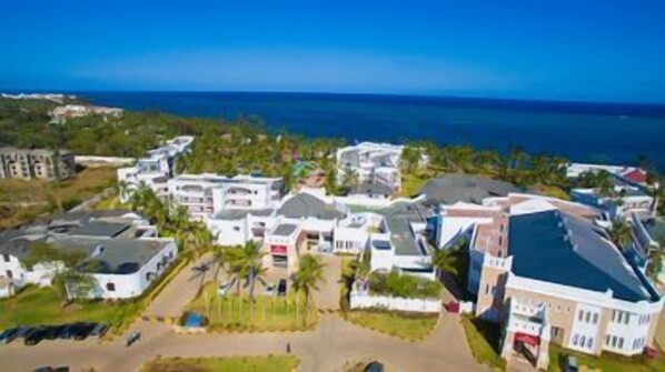 A coastal hotel with multiple buildings, a parking area, and a view of the ocean. - Prideinn Paradise Beach Resort & Spa Mombasa (Mombasa)