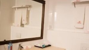 Un baño con lavabo, espejo e inodoro.