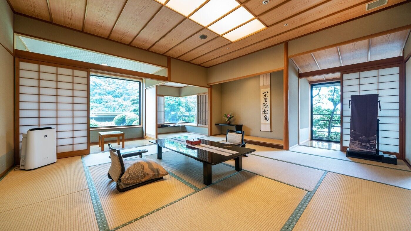 A traditional Japanese room with tatami flooring, sliding doors, and a low table with cushions.