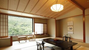 Una habitación japonesa tradicional con suelo de tatami, una mesa baja y puertas correderas shoji.