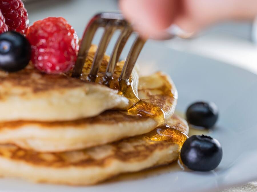 Pancakes with syrup and berries on a plate.