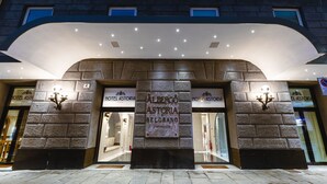 The exterior of Hotel Astoria Belgrano with a stone facade and illuminated signage. - Hotel Astoria (Genoa)