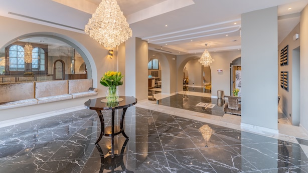 A spacious lobby with marble flooring, large chandeliers, and seating areas. - Hotel Astoria (Genoa)