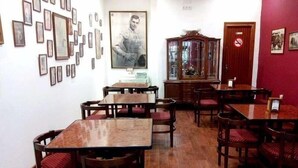 A dining area with wooden tables and chairs, a large cabinet, and framed pictures on the walls. - Nuevo Hotel Vista Alegre (Valdepenas)