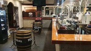 A bar area with stools, a counter, and a large barrel labeled 'PATA NECRA'. - Nuevo Hotel Vista Alegre (Valdepenas)