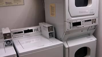 A laundry area with a washing machine, a dryer, and a stacked dryer.