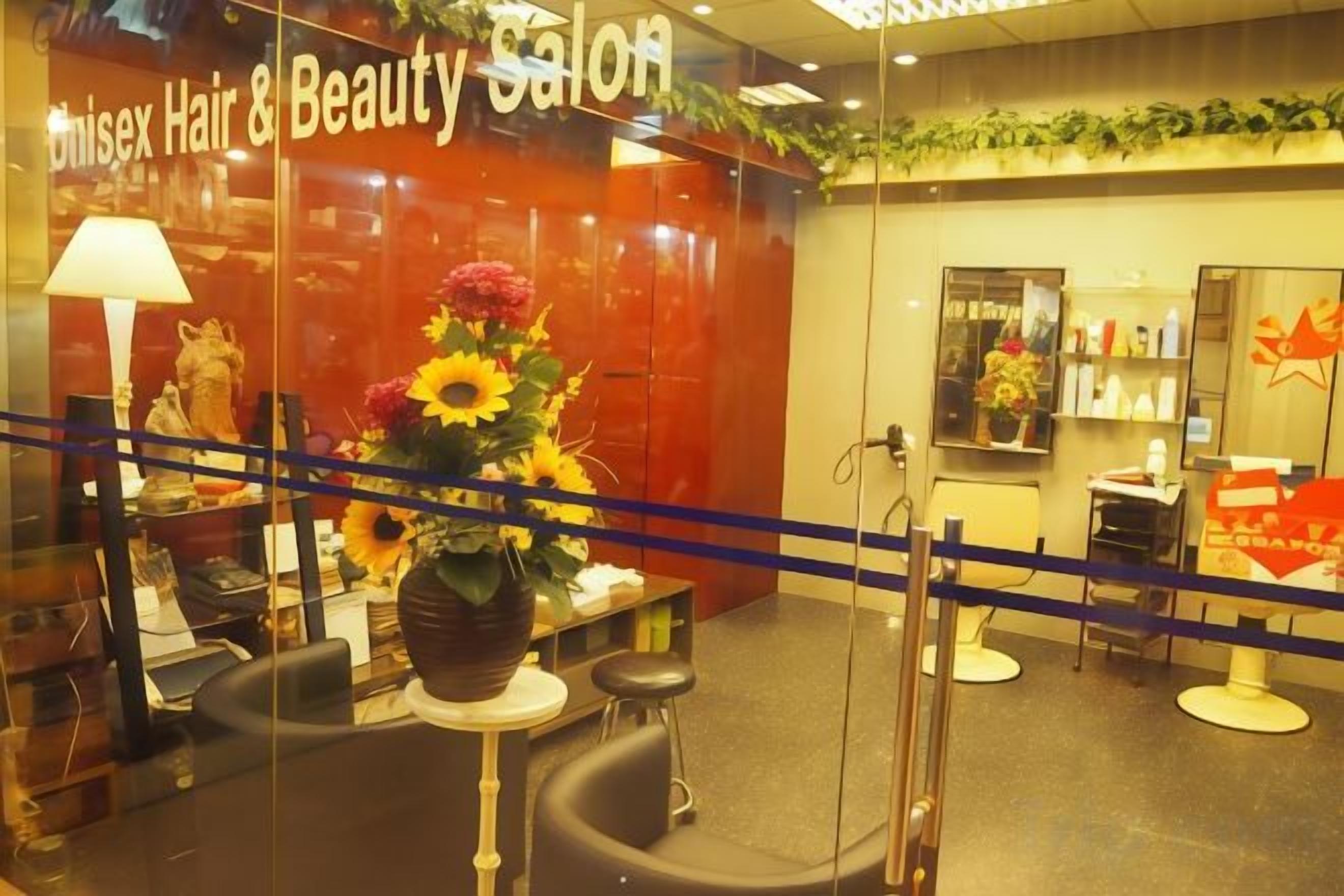 A hair and beauty salon with a reception area, salon chairs, and a display of hair products.