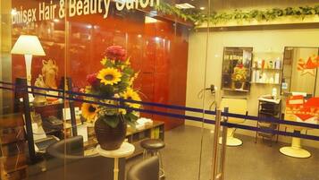 A hair and beauty salon with a reception area, salon chairs, and a display of hair products.